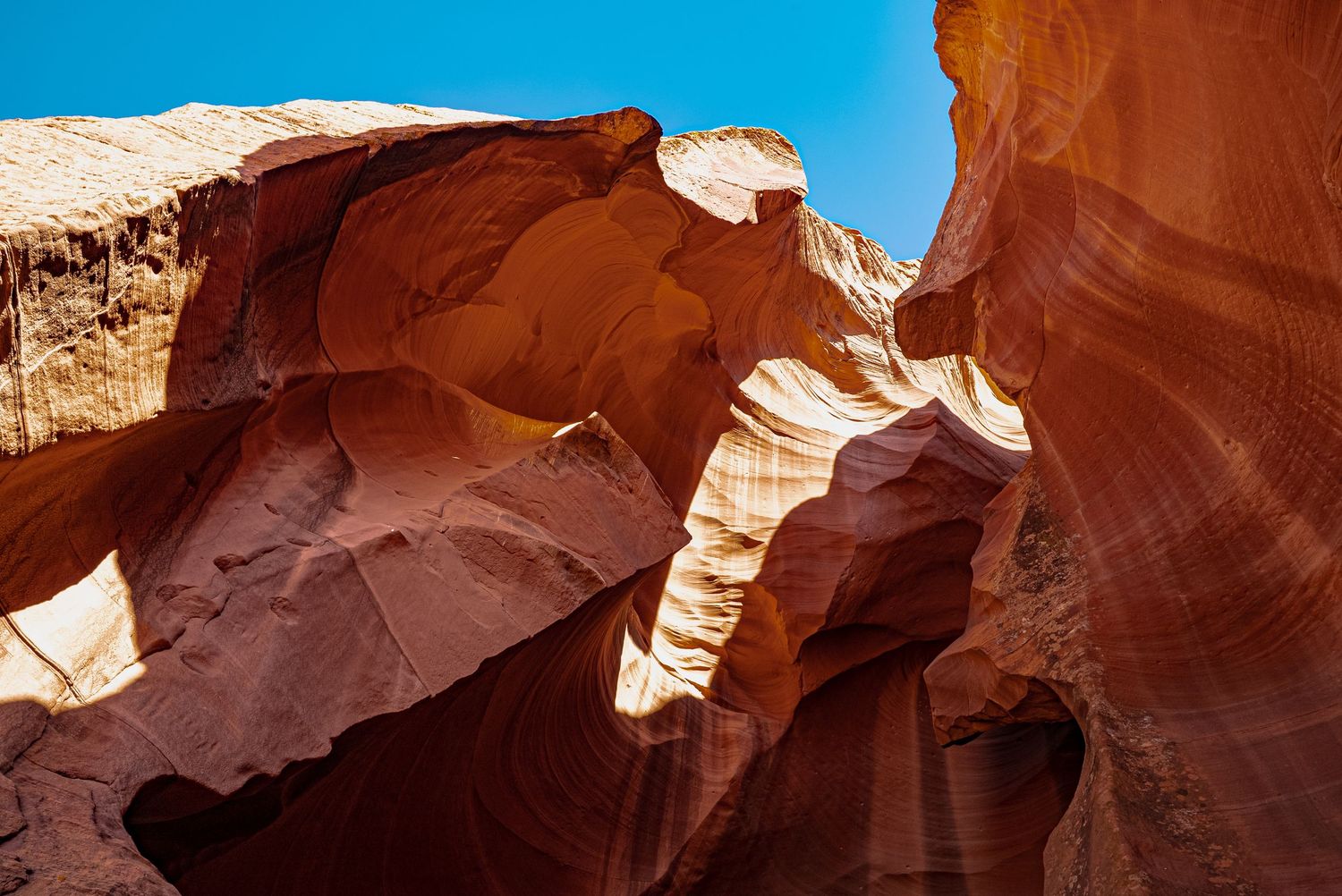 Dramatic red sandstone walls of Antelope Canyon with light streaming through the narrow opening.