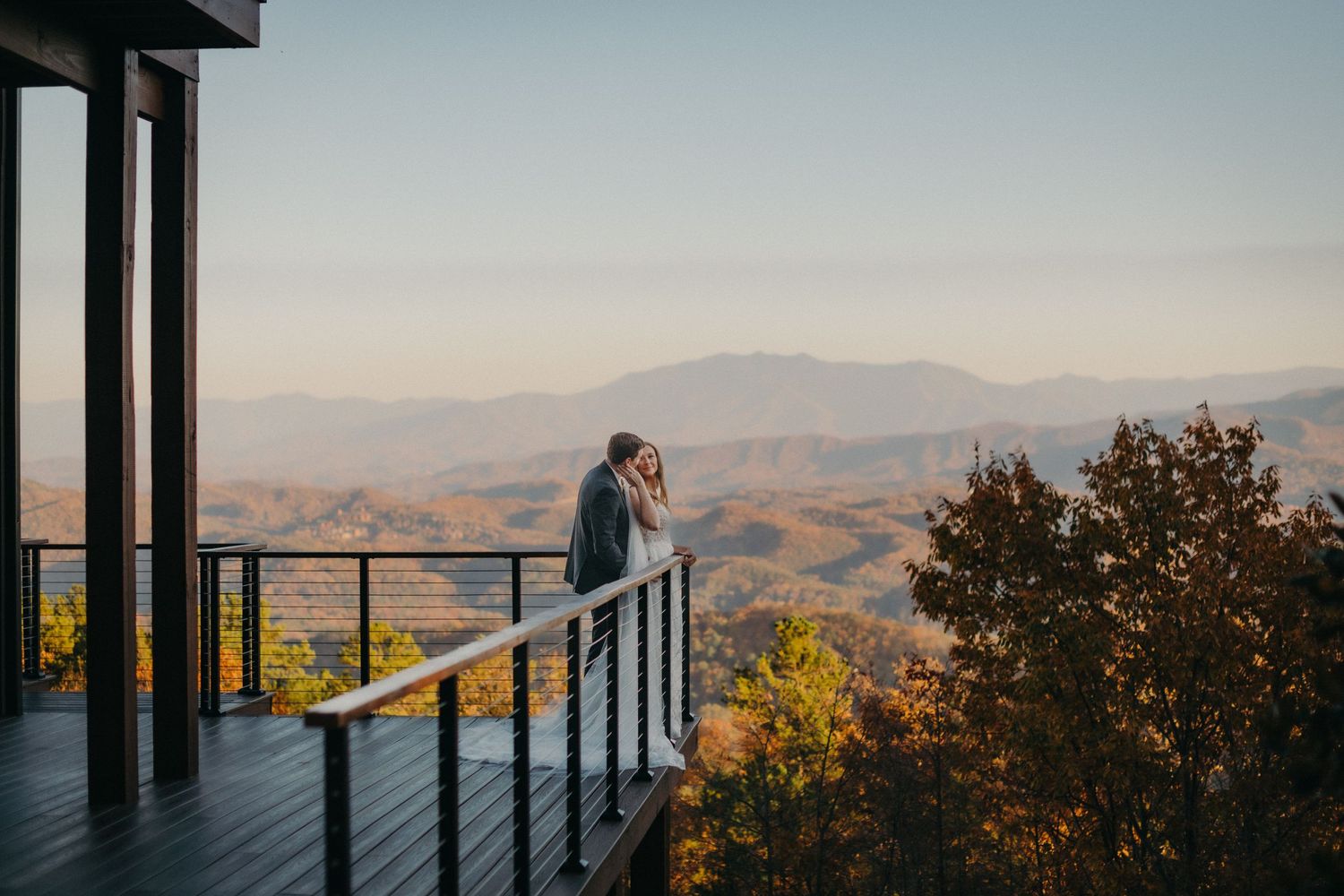 Scenic mountain vista view from a deck at sunset with string lights overhead.