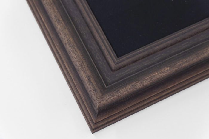 Dark bronze ornate wood picture frame corner with layered molding detail on white background.