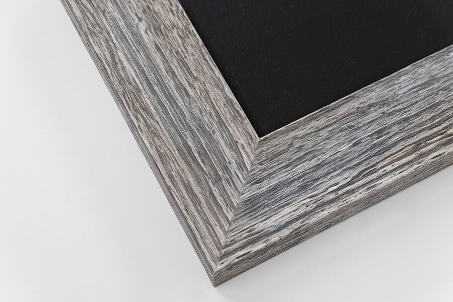 Gray distressed rustic wood picture frame corner with black chalkboard surface on white background.