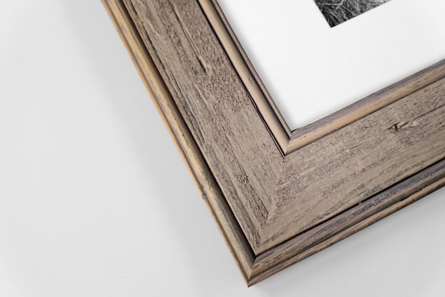 Natural rustic barnwood picture frame corner with white mat and photo on white background.