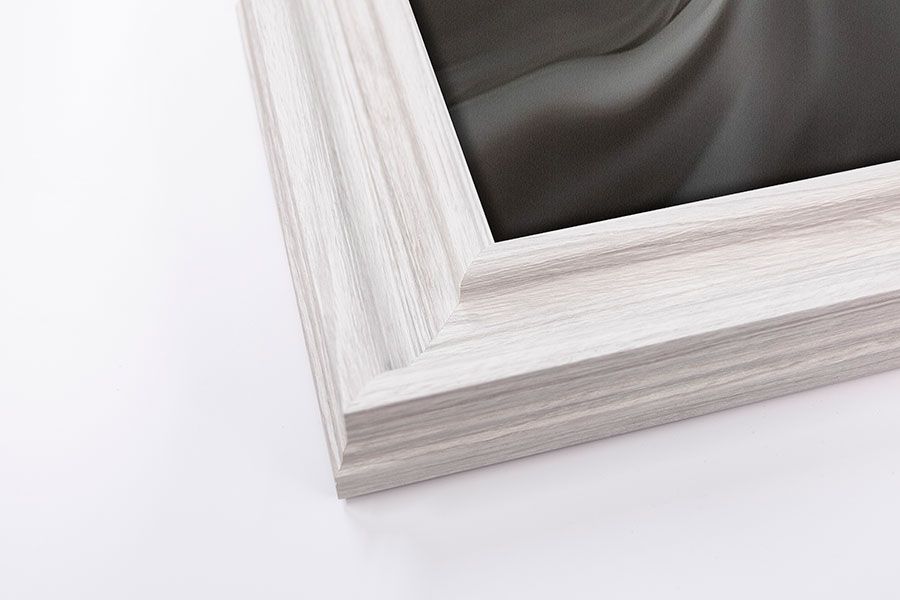 Close-up corner detail of a white distressed wood picture frame on a white background.