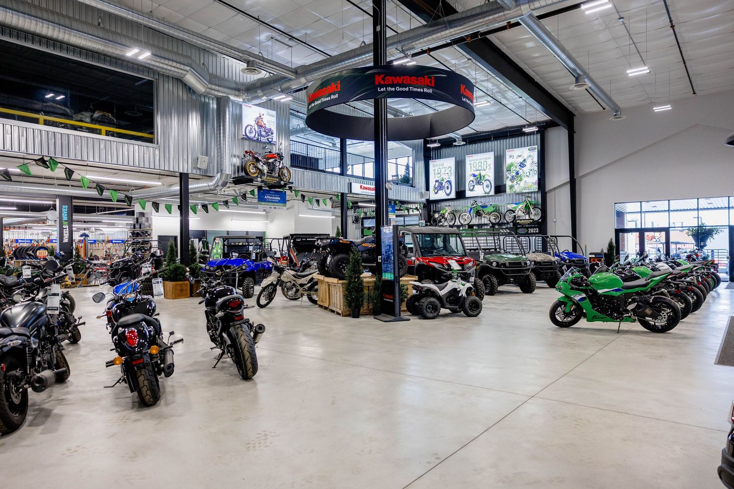 Large motorcycle dealership showroom featuring rows of colorful bikes and powersports vehicles on display.
