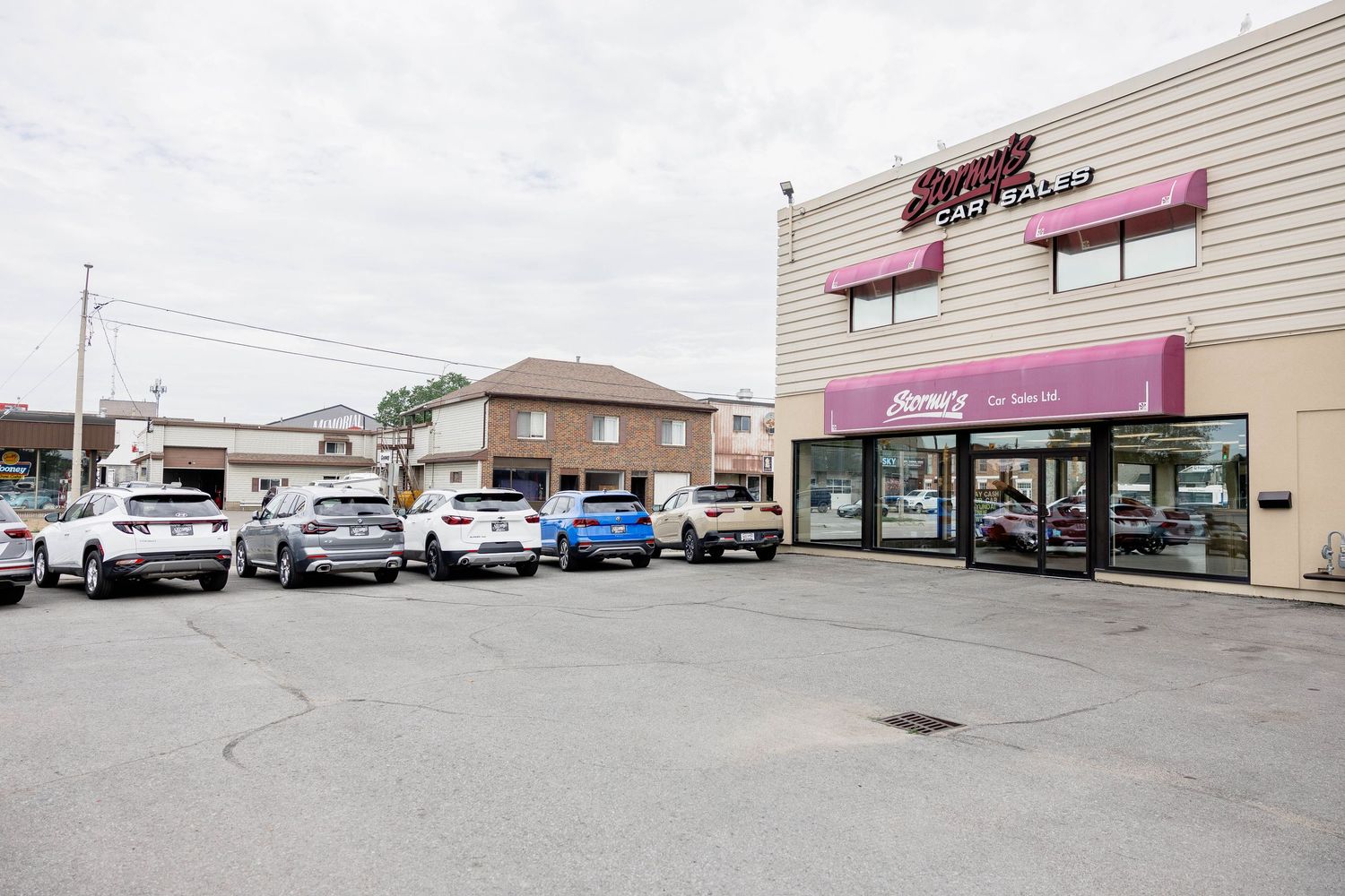 Stormy's Car Sales dealership building exterior with full parking lot of pre-owned vehicles.