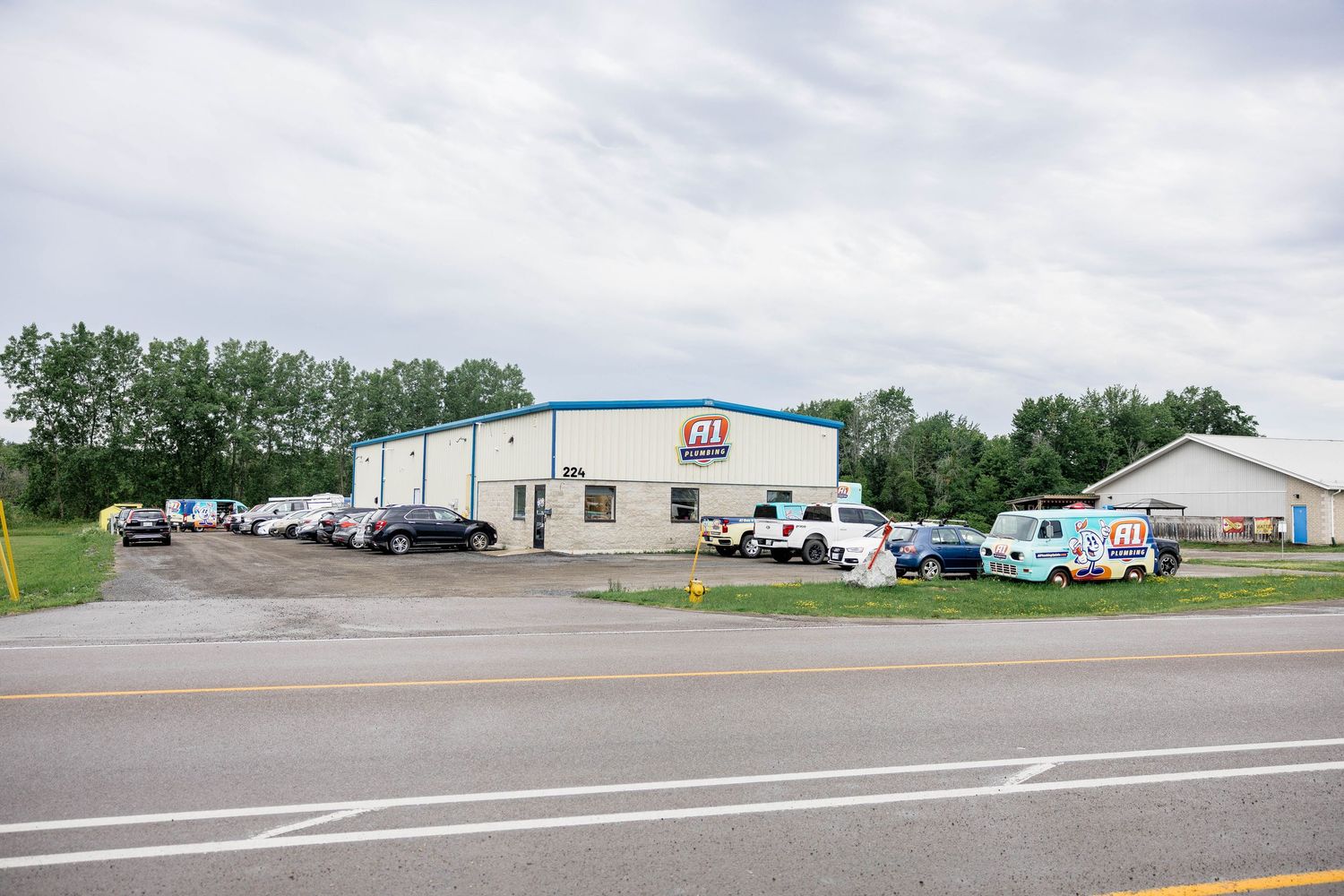 A1 Plumbing company headquarters building with fleet of branded service vans parked outside.