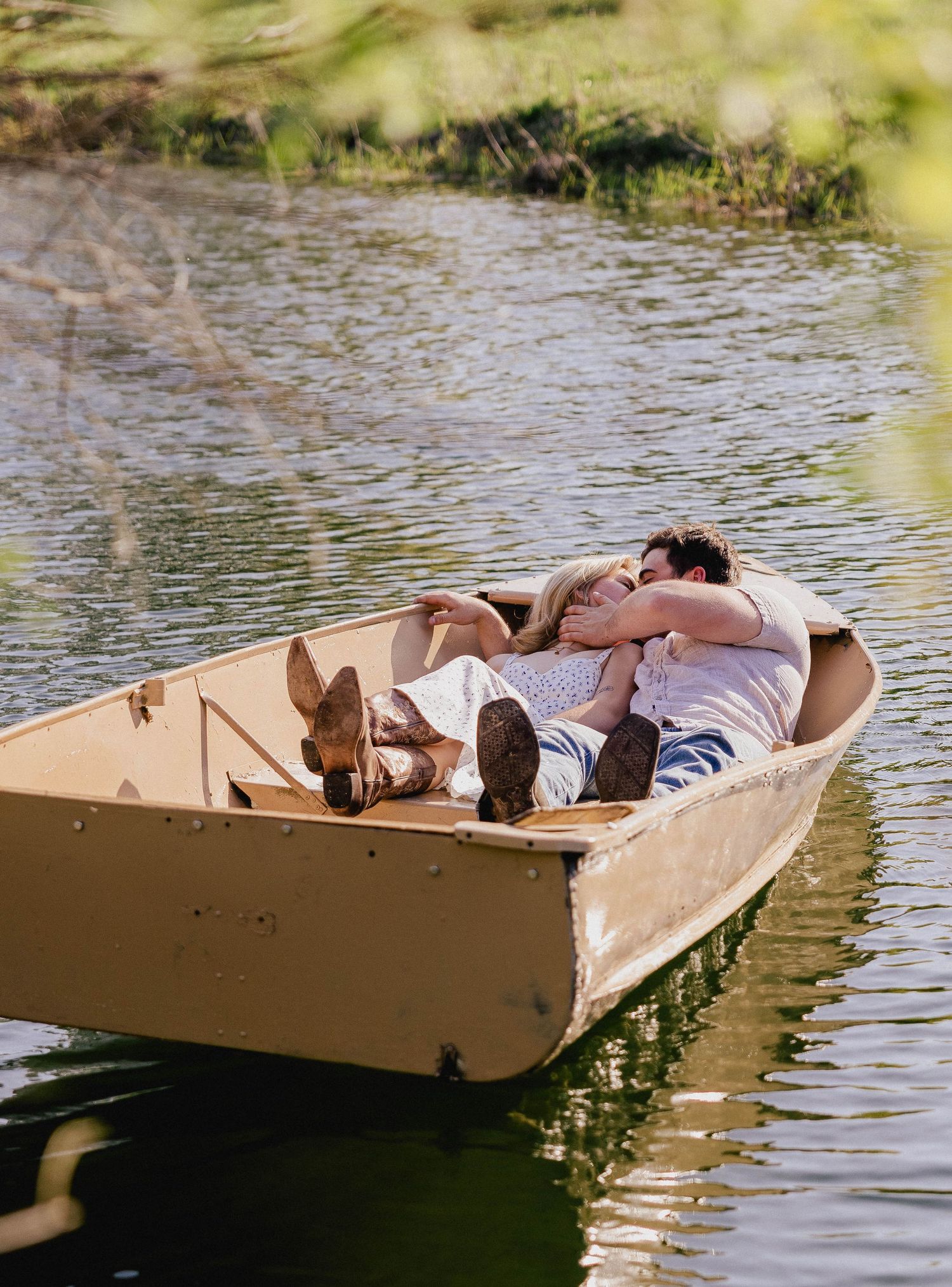 Romantic couple lying together in a small boat floating on a peaceful lake.