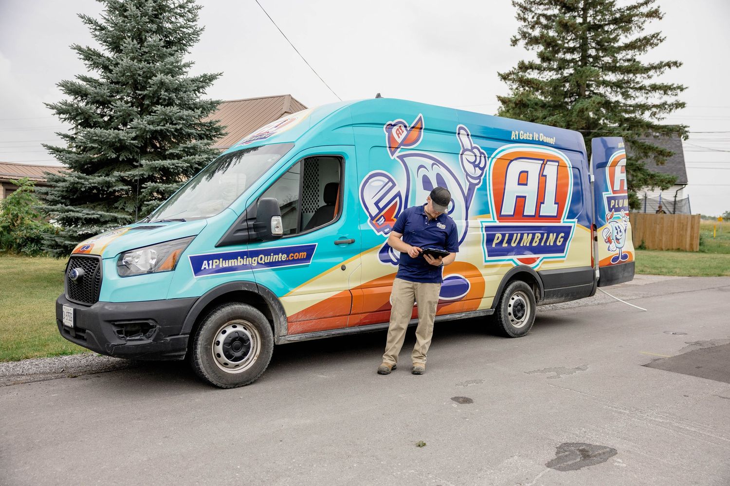 A1 Plumbing technician standing beside a colorful branded service van in a parking lot.