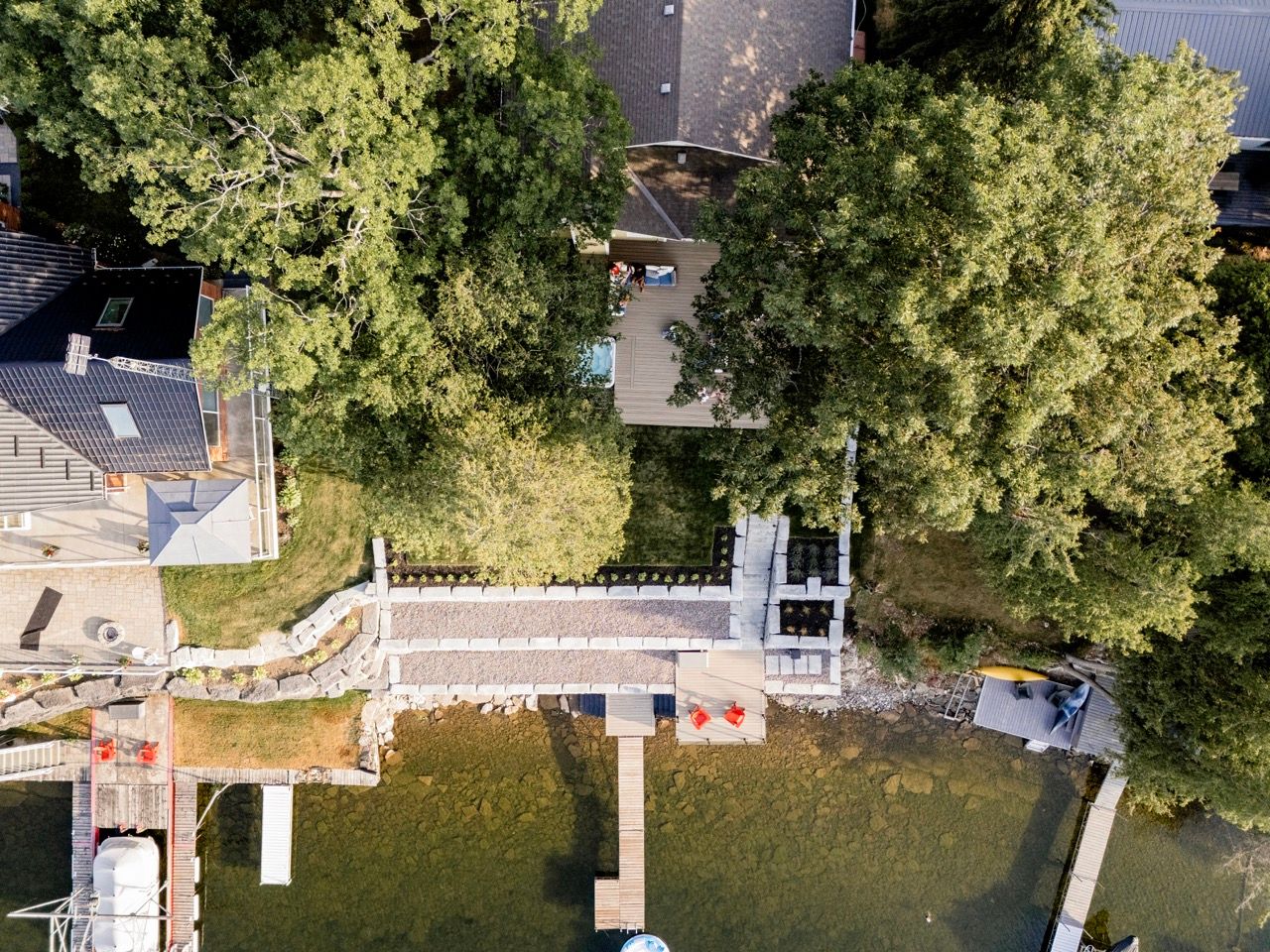 Bird's eye view of waterfront property featuring private dock and natural tree canopy.
