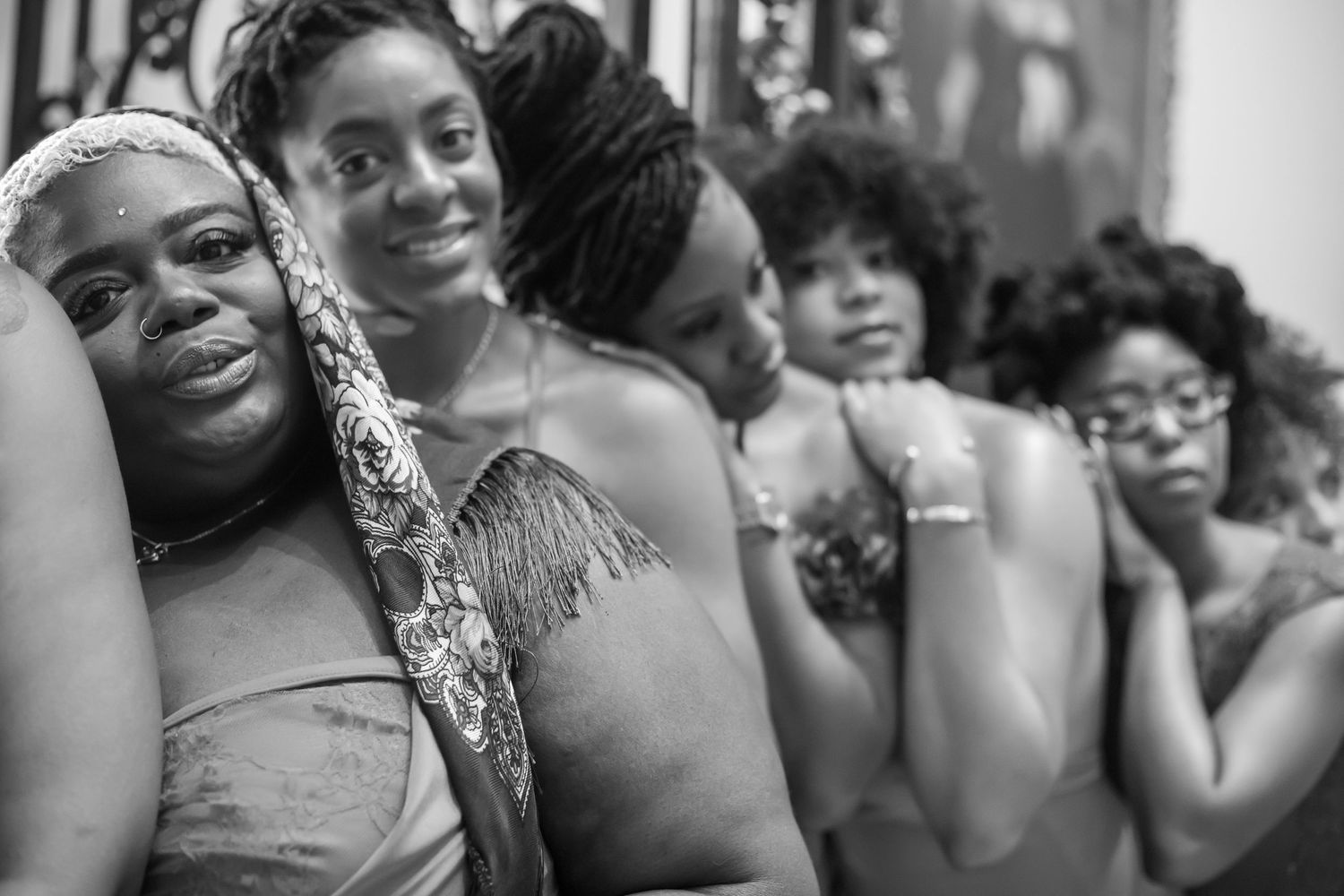 Black and white photo of women leaning together smiling.