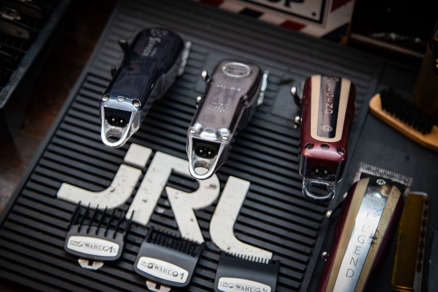 JRL brand professional hair clippers and trimmers displayed on a grooming mat.
