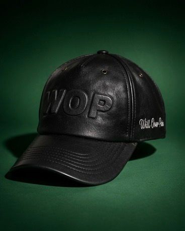 Black leather WOP snapback cap with embossed logo and cursive text on green background.
