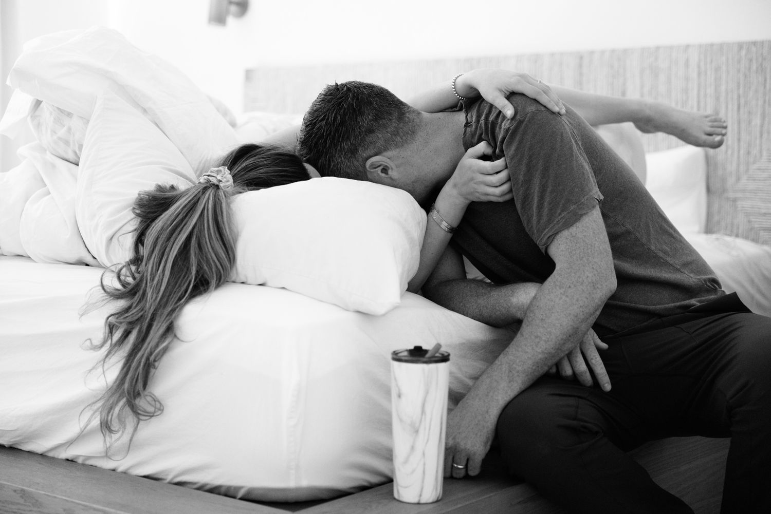 A couple shares an intimate embrace during labor on a bedroom floor.