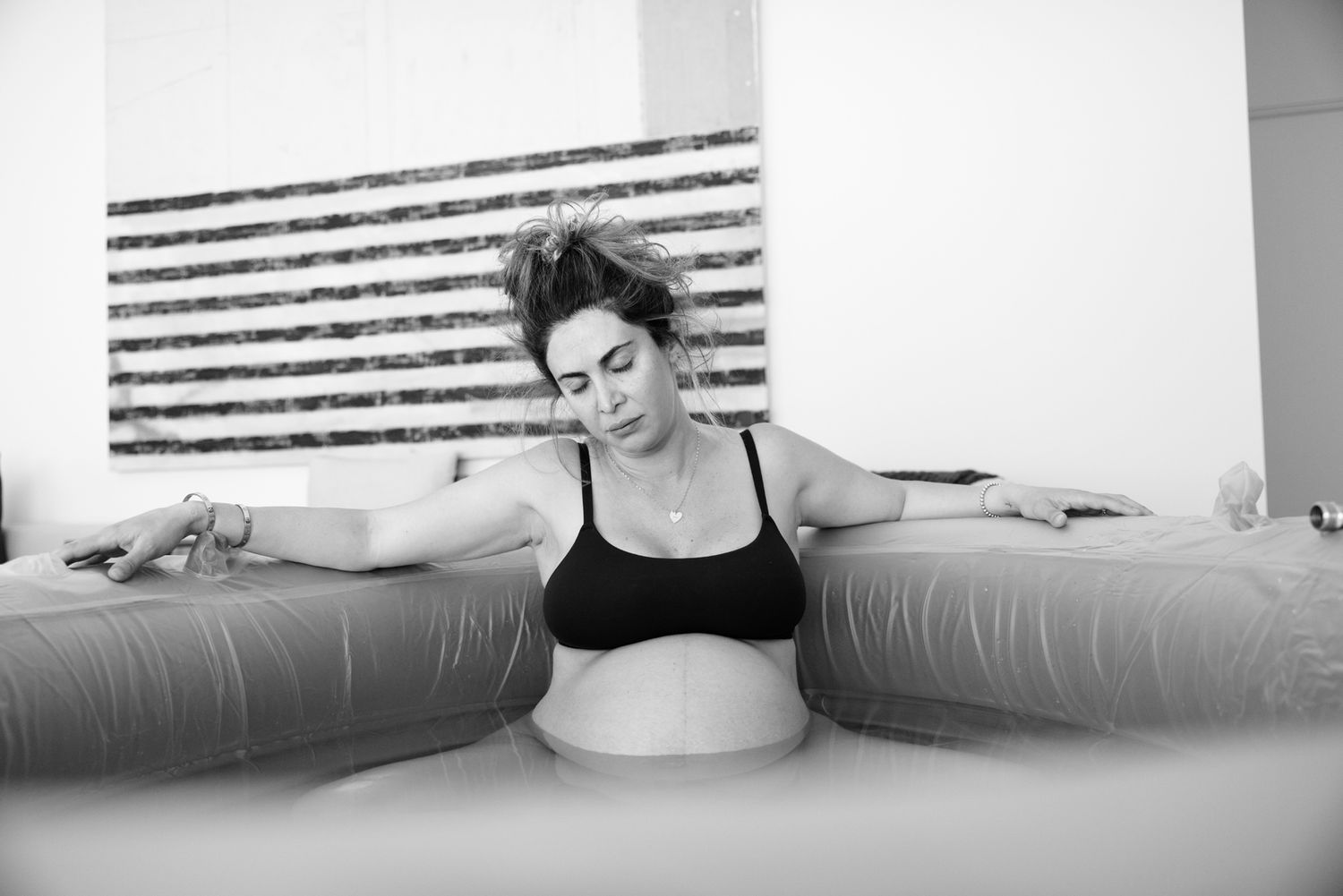A pregnant woman relaxes in an inflatable birthing pool during labor.