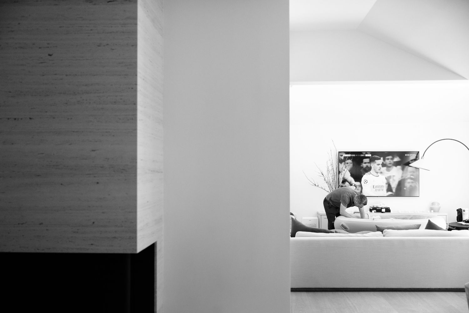 A pregnant woman rests on a sofa in a modern minimalist living room.