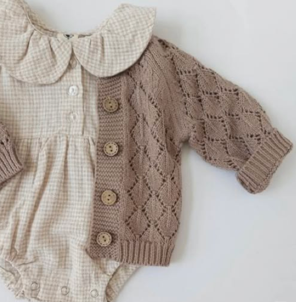 Baby romper with beige gingham collar and brown diamond knit cardigan with wooden buttons.