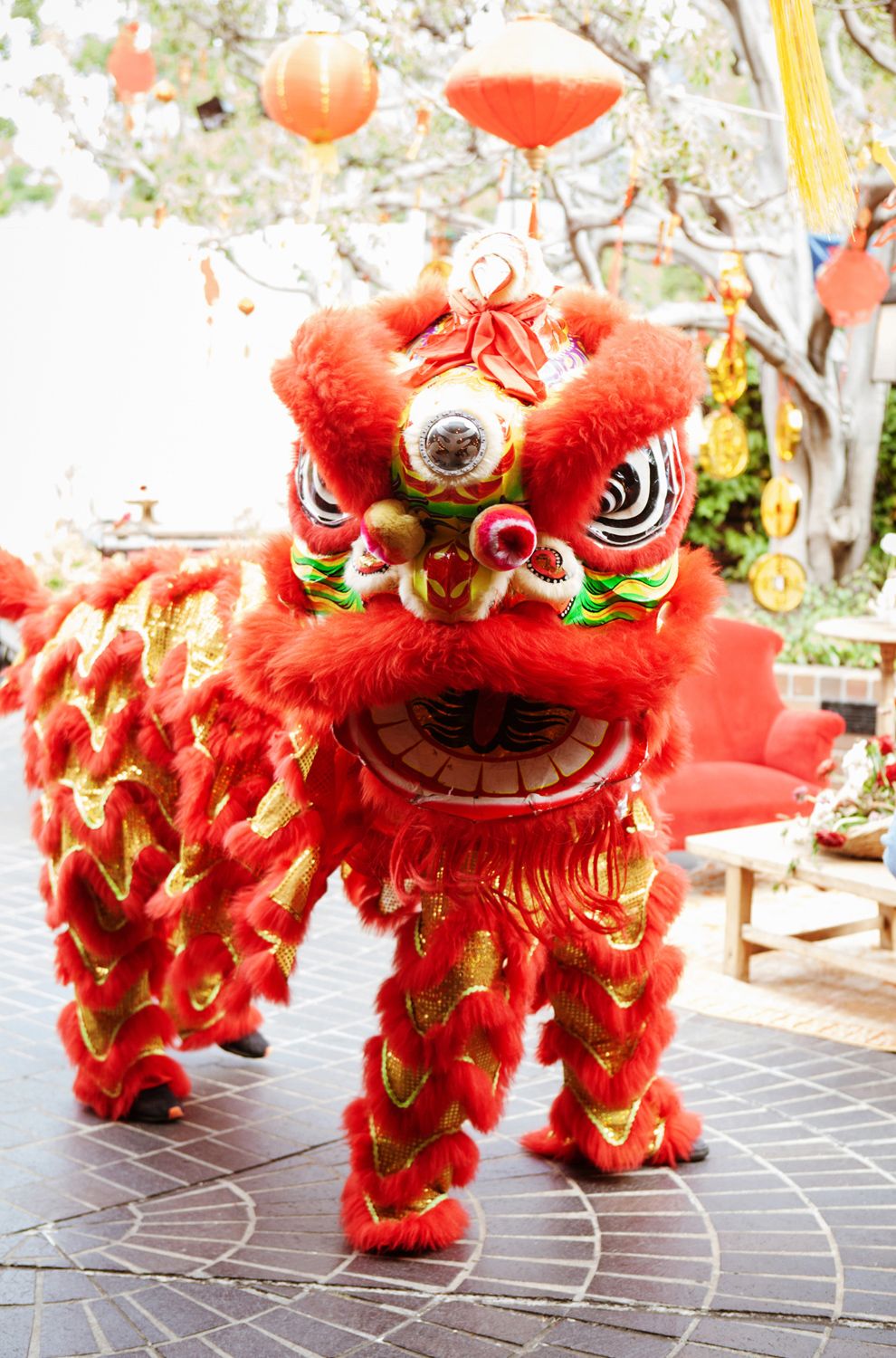 Vibrant red Chinese lion dance costume displayed outdoors during a festive celebration.