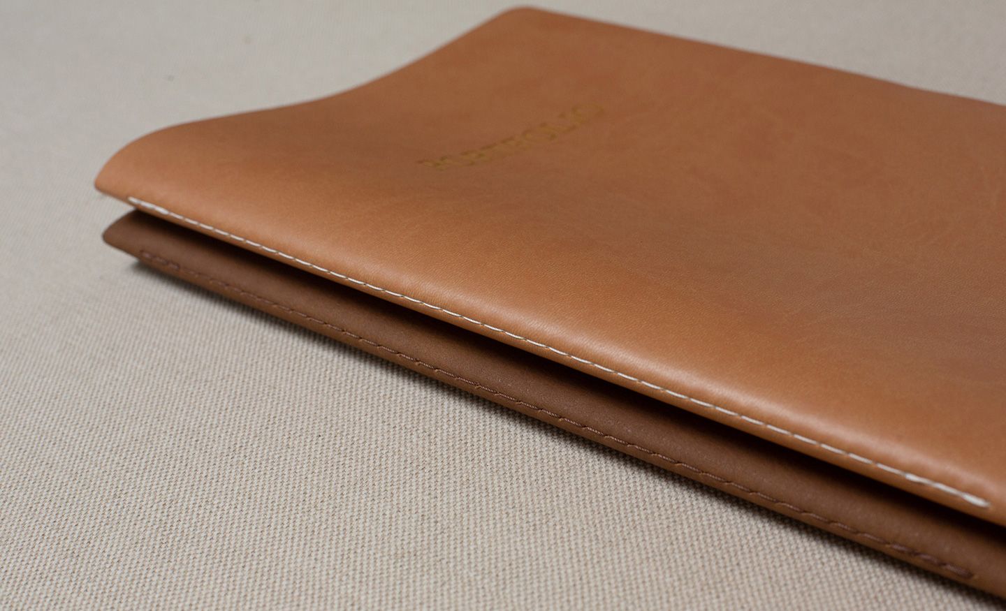 A brown leather wallet or cardholder shown from multiple angles against a light gray background.
