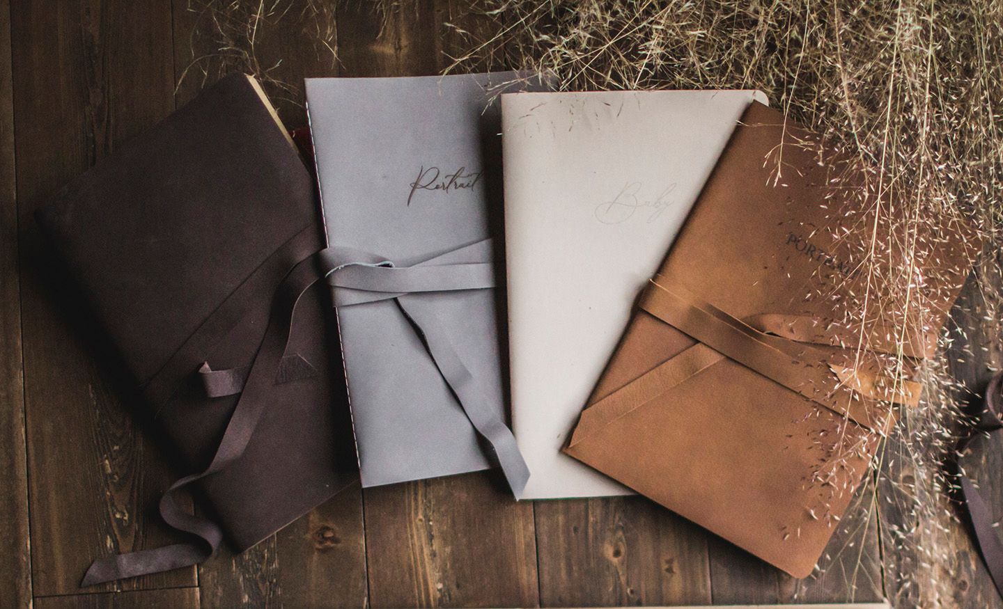 Handcrafted leather wallets and accessories displayed on rustic wooden surface with scattered tools and materials.