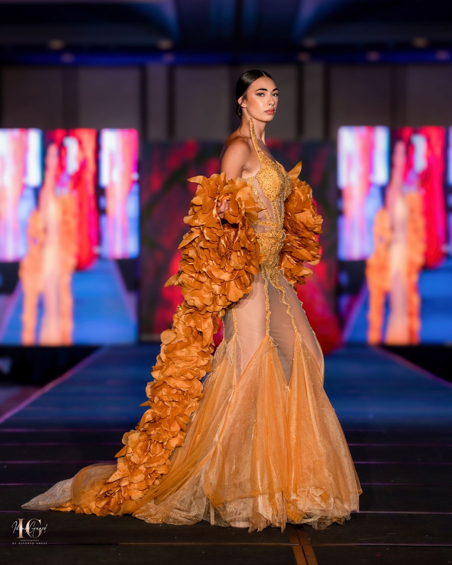 Elegant peach-colored ball gown with voluminous ruffled details glides down the runway.