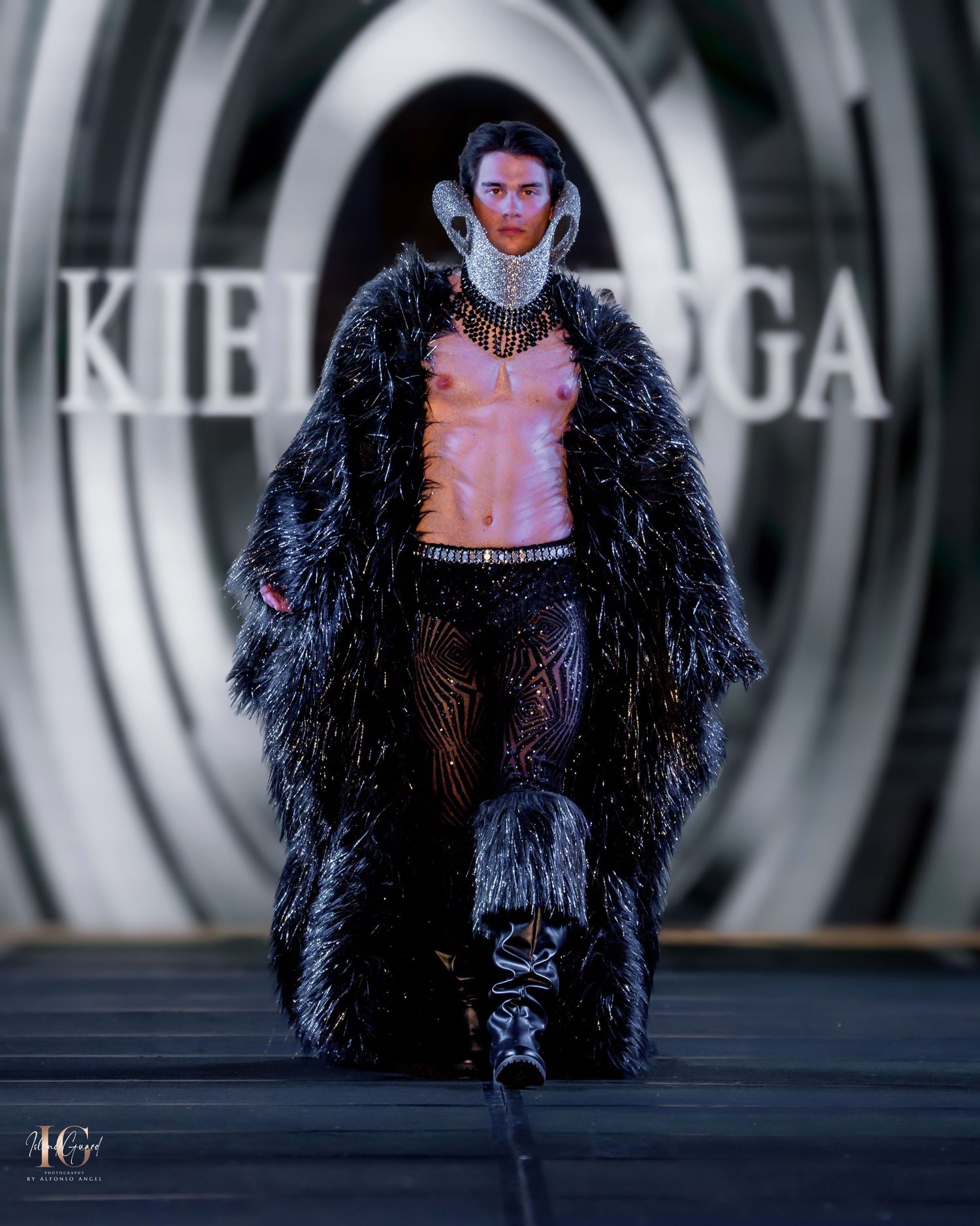 Theatrical runway presentation featuring feathered coat against circular branded backdrop.