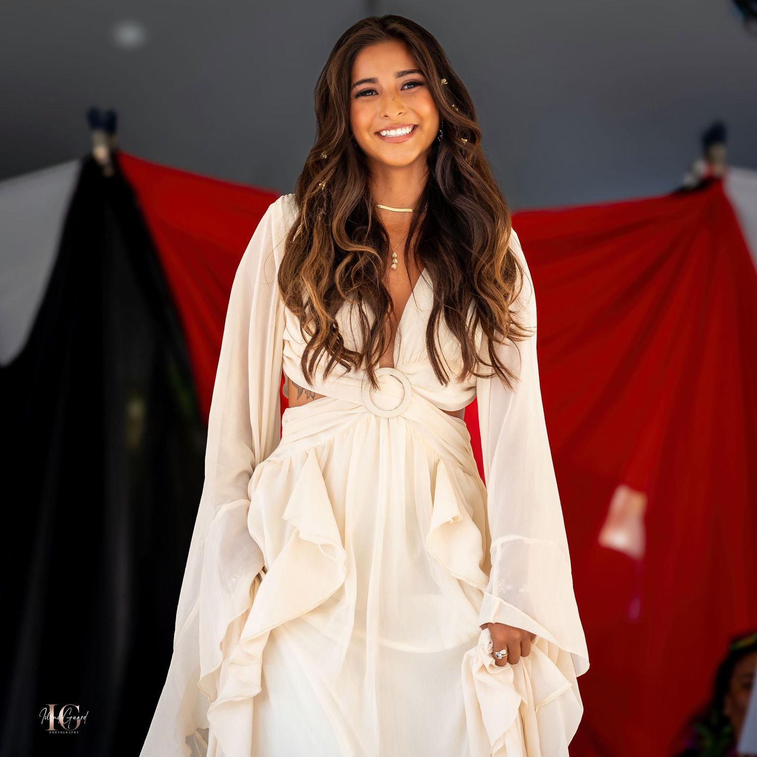 Fashion shoot featuring model in romantic white ruffled blouse against studio setting.