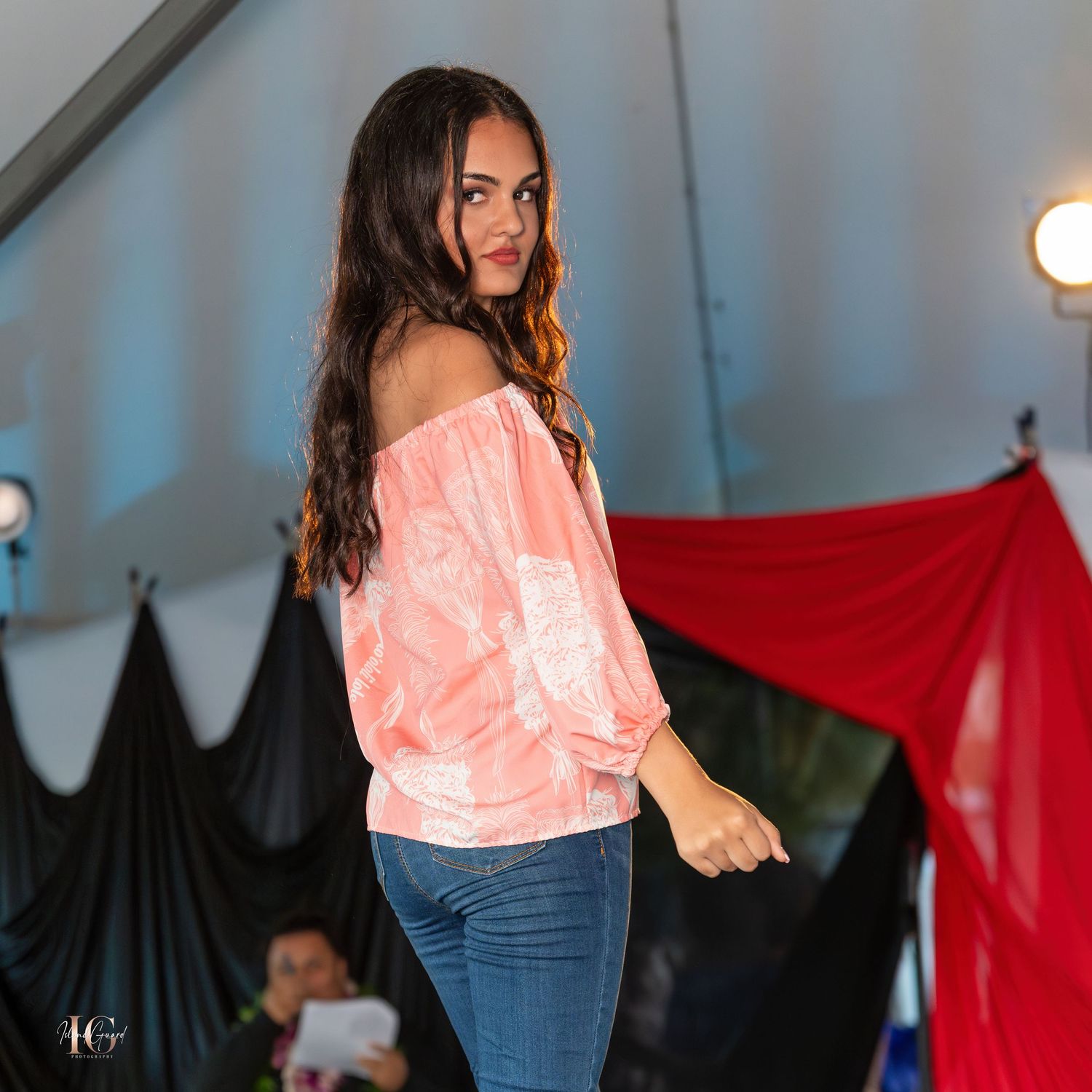 Models showcase casual pink tops and denim jeans collection on fashion catwalk.