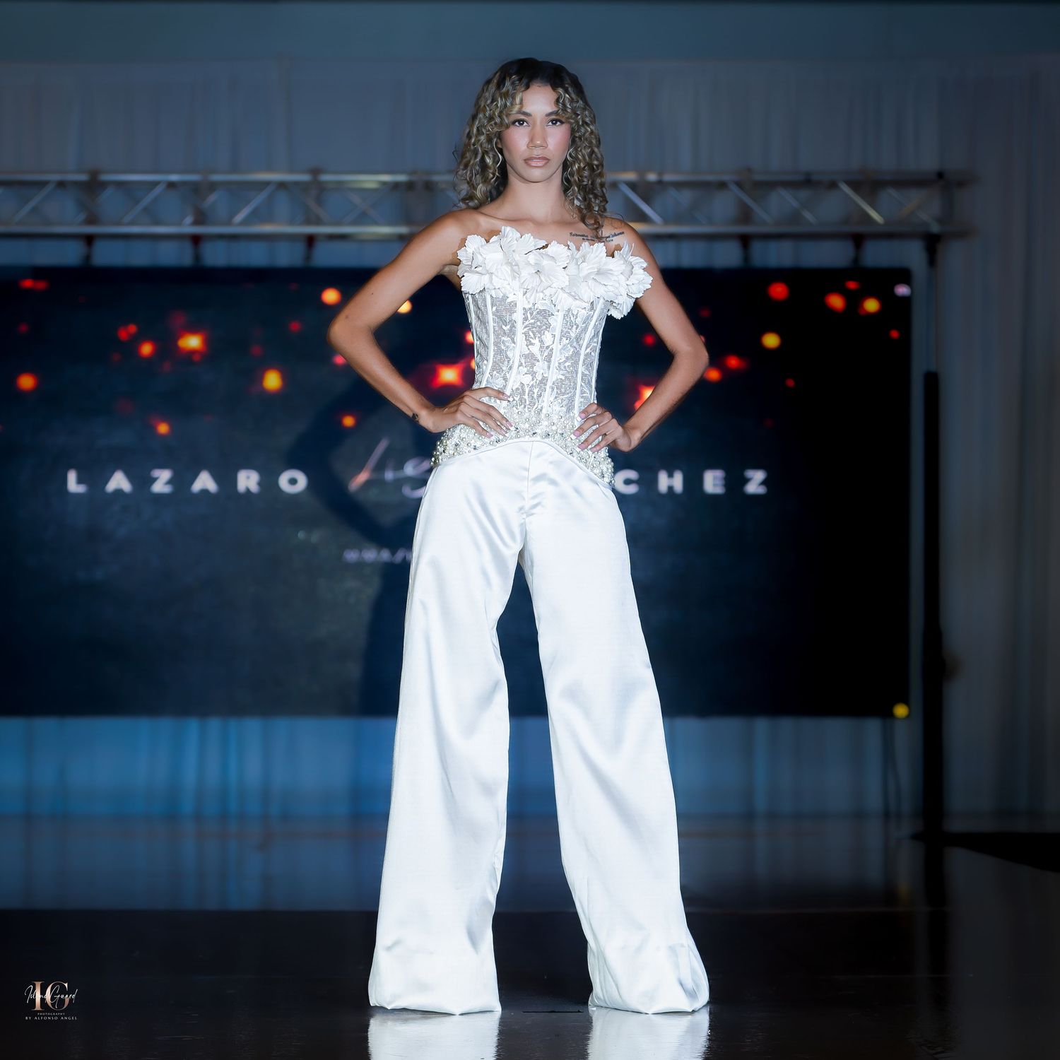 White corset top with wide-leg pants ensemble showcased at fashion show.