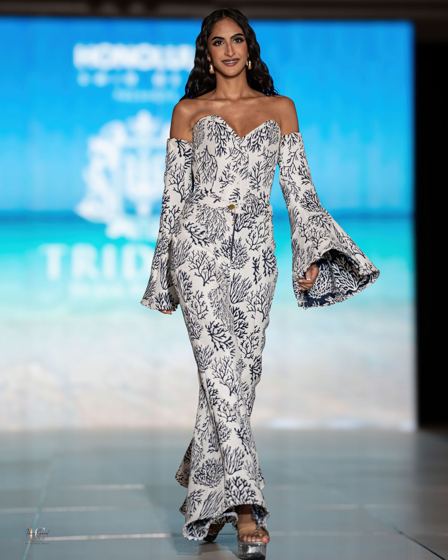 Fashion model in black and white patterned off-shoulder maxi dress with dramatic bell sleeves.