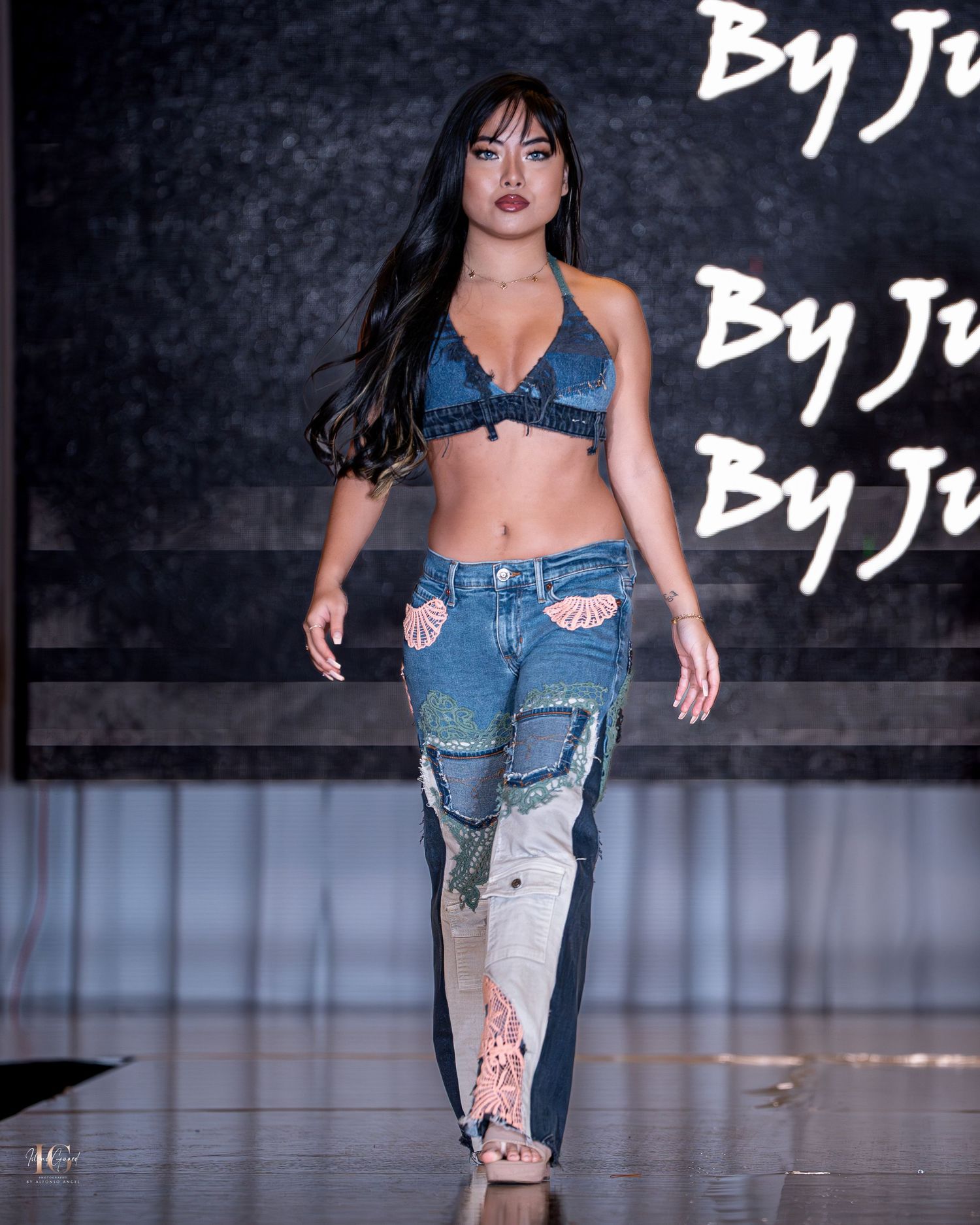 Model struts runway in distressed denim jeans and matching cropped top.