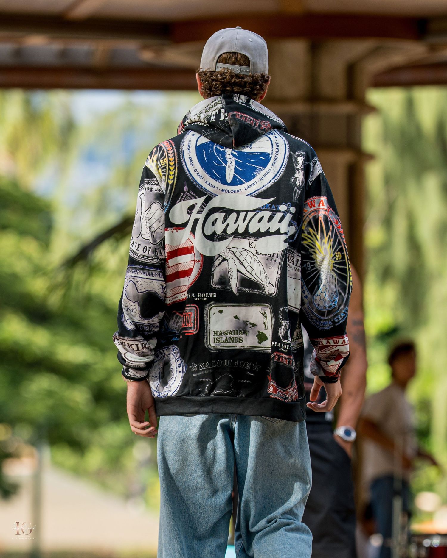 Closeup view of denim jacket with patches and embroidery showing Hawaii text and American flag details.