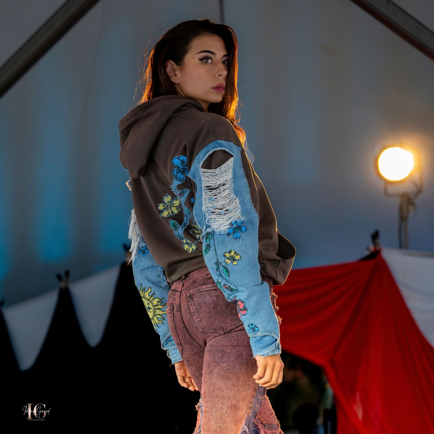 Fashion show featuring casual denim and knitwear combinations with moody lighting.