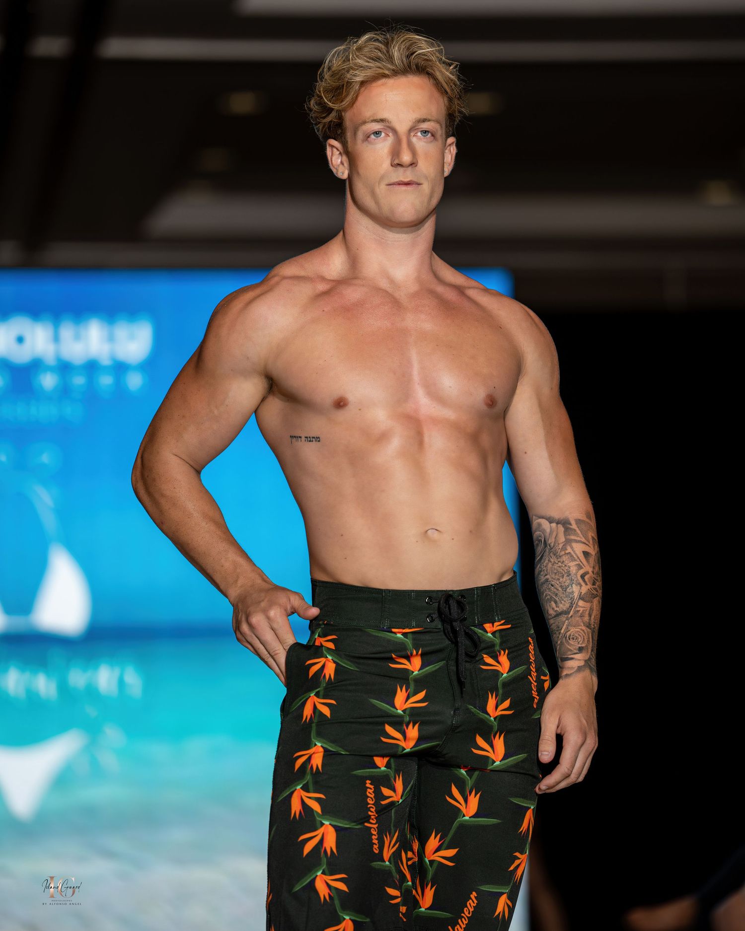 Bird of paradise print swim trunks modeled on runway at Honolulu fashion show.
