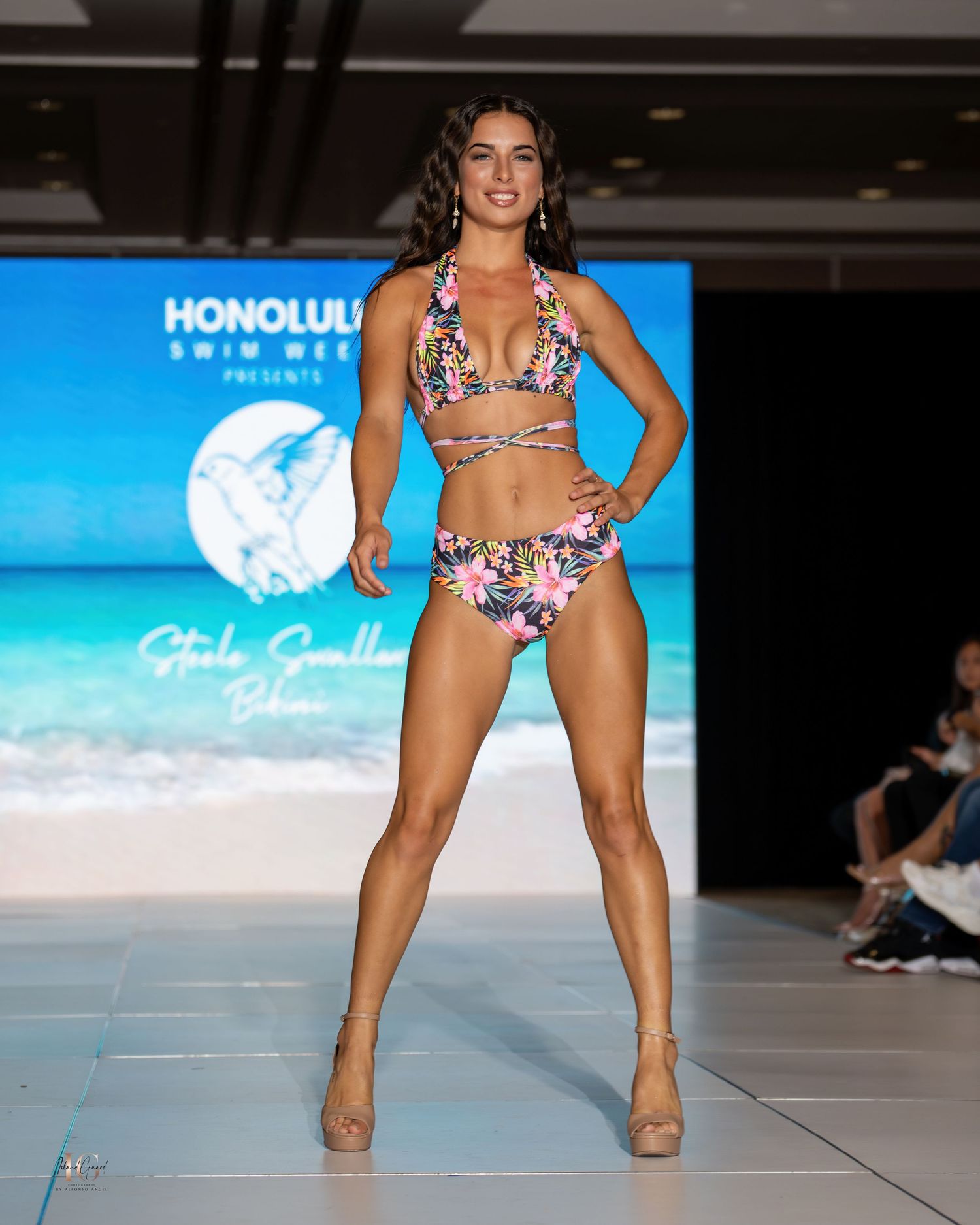 Model presents colorful floral print bikini at Honolulu swimwear fashion show.