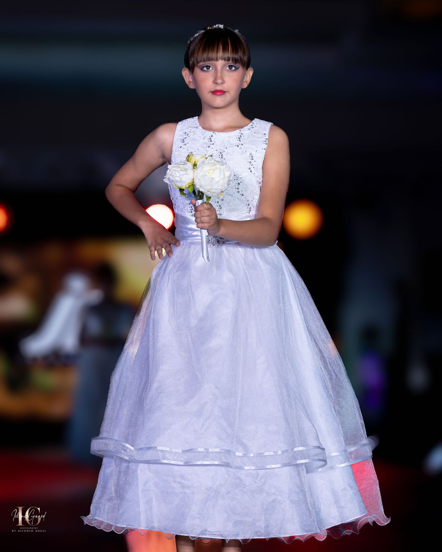White tea-length dress with floral appliques and full skirt on fashion runway.