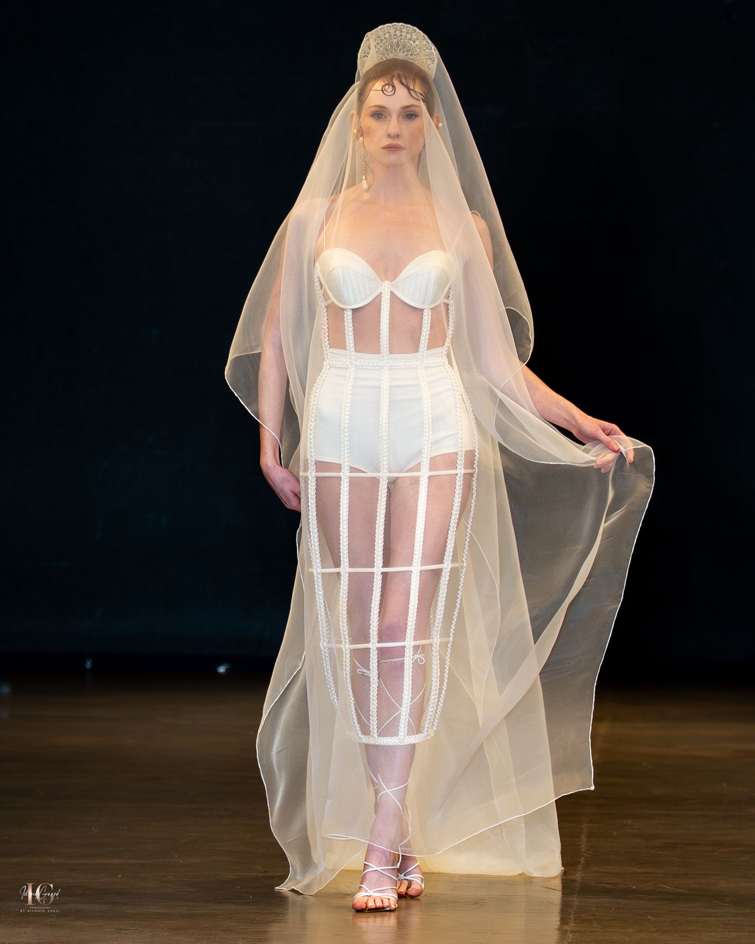 A figure in a white corset dress and sheer veil stands in various poses against a dark background.