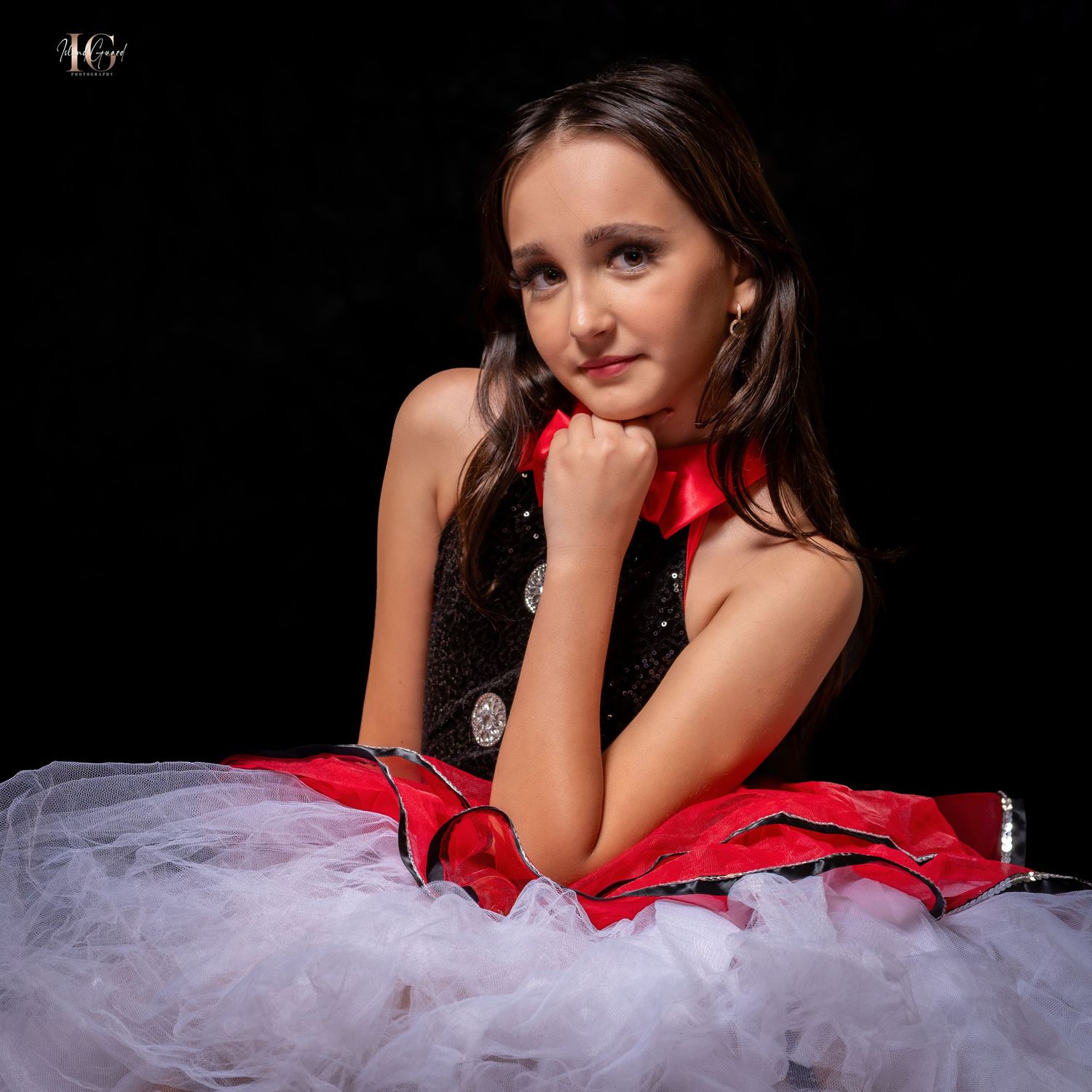 A model in a red and white formal dress poses elegantly against a black background.