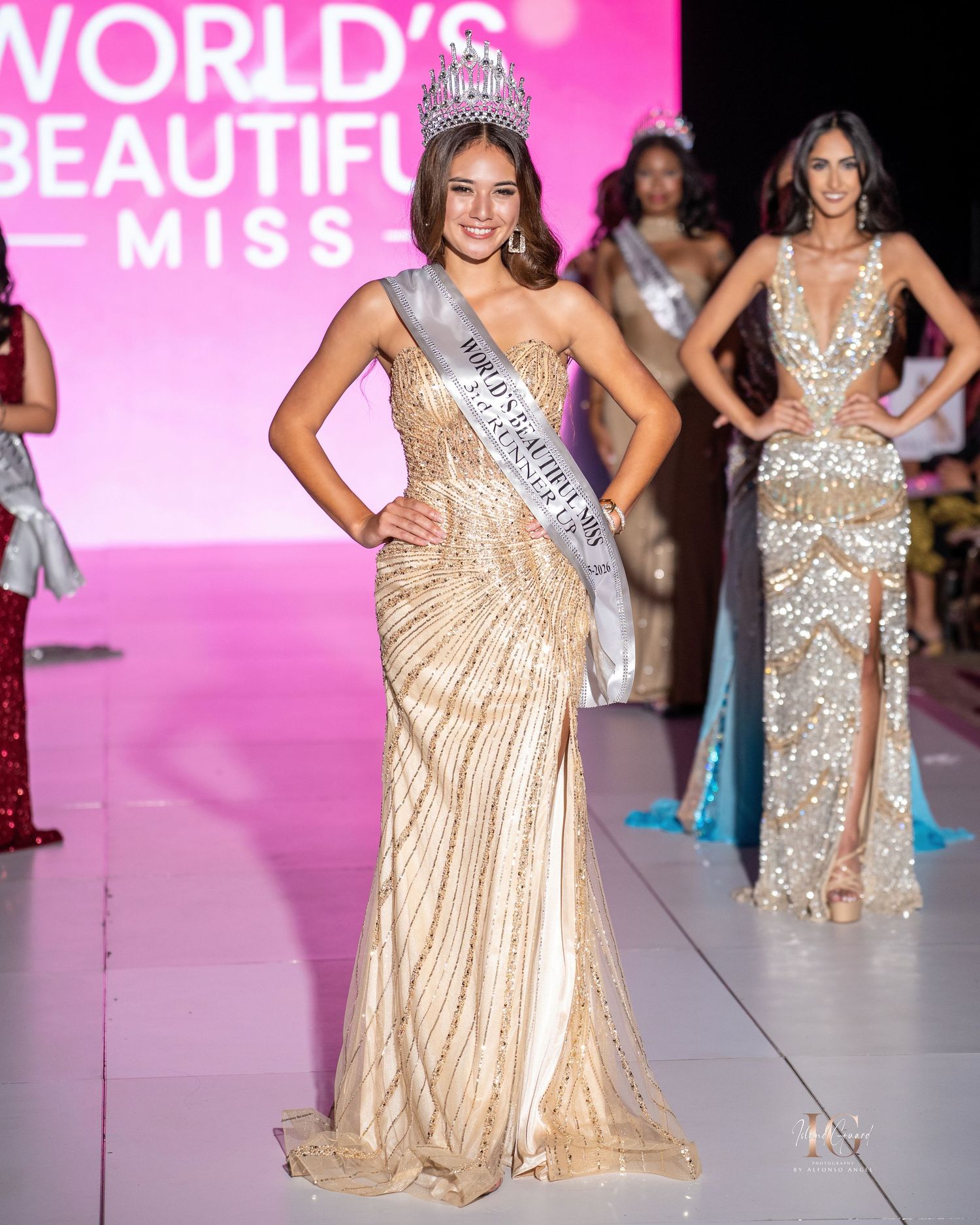 Beauty pageant contestant wearing a sparkling champagne-colored evening gown poses on pink-lit runway stage.