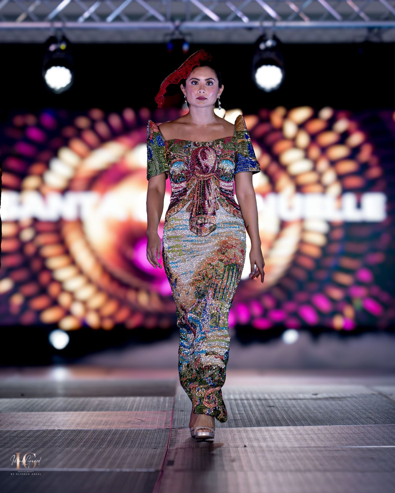 Artistic printed dress with intricate patterns and short sleeves presented on runway with circular light display.