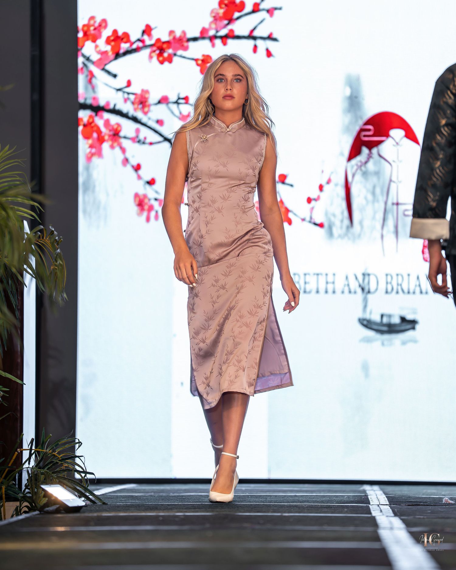 Model walks the runway in a soft mauve suede dress during a fashion show presentation.