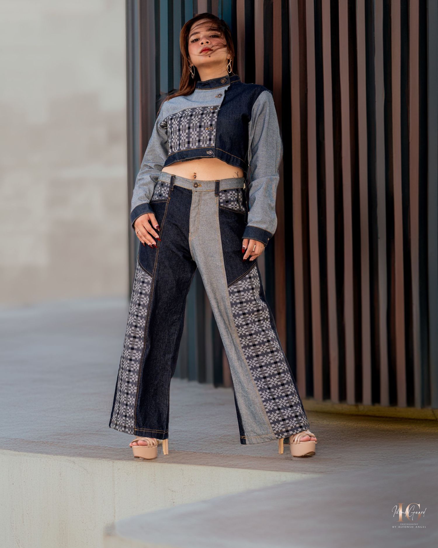 Fashion model wearing a modern black and grey patchwork crop top and wide-leg pants with geometric patterns.