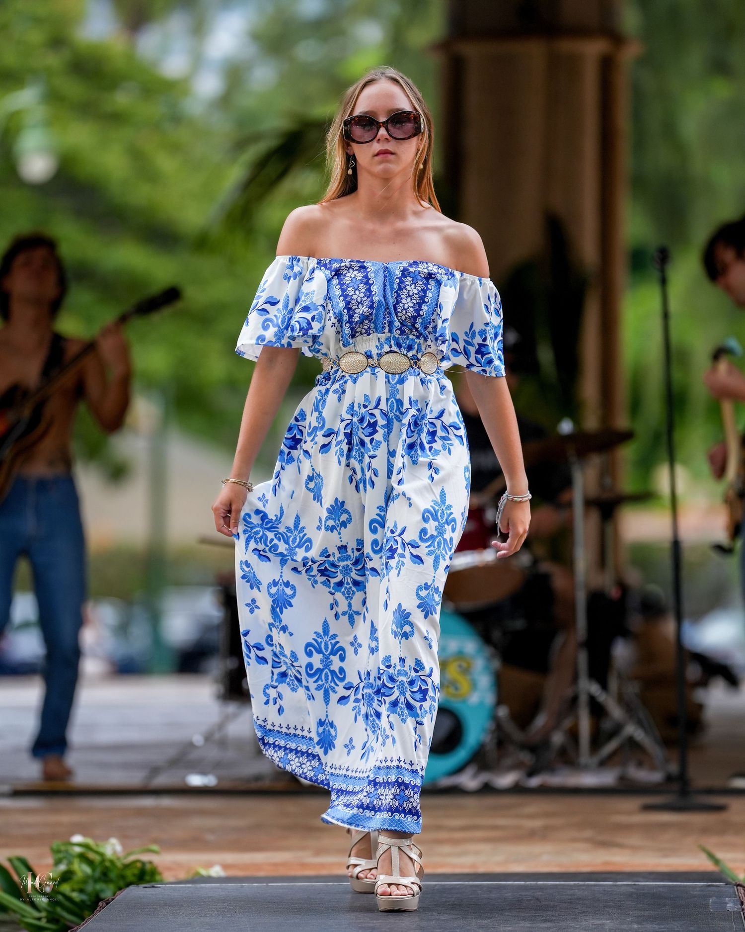Summer fashion in a blue and white floral off-shoulder dress styled with sunglasses and sandals for outdoor events.