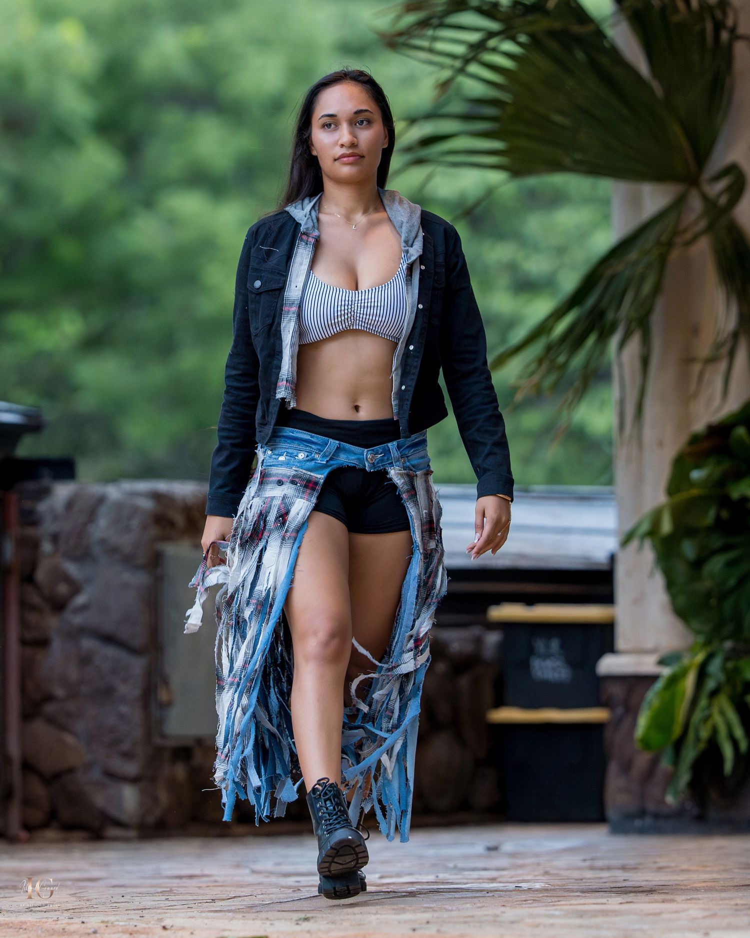 A person in a black jacket and denim shorts poses outdoors in a series of dynamic fashion shots.