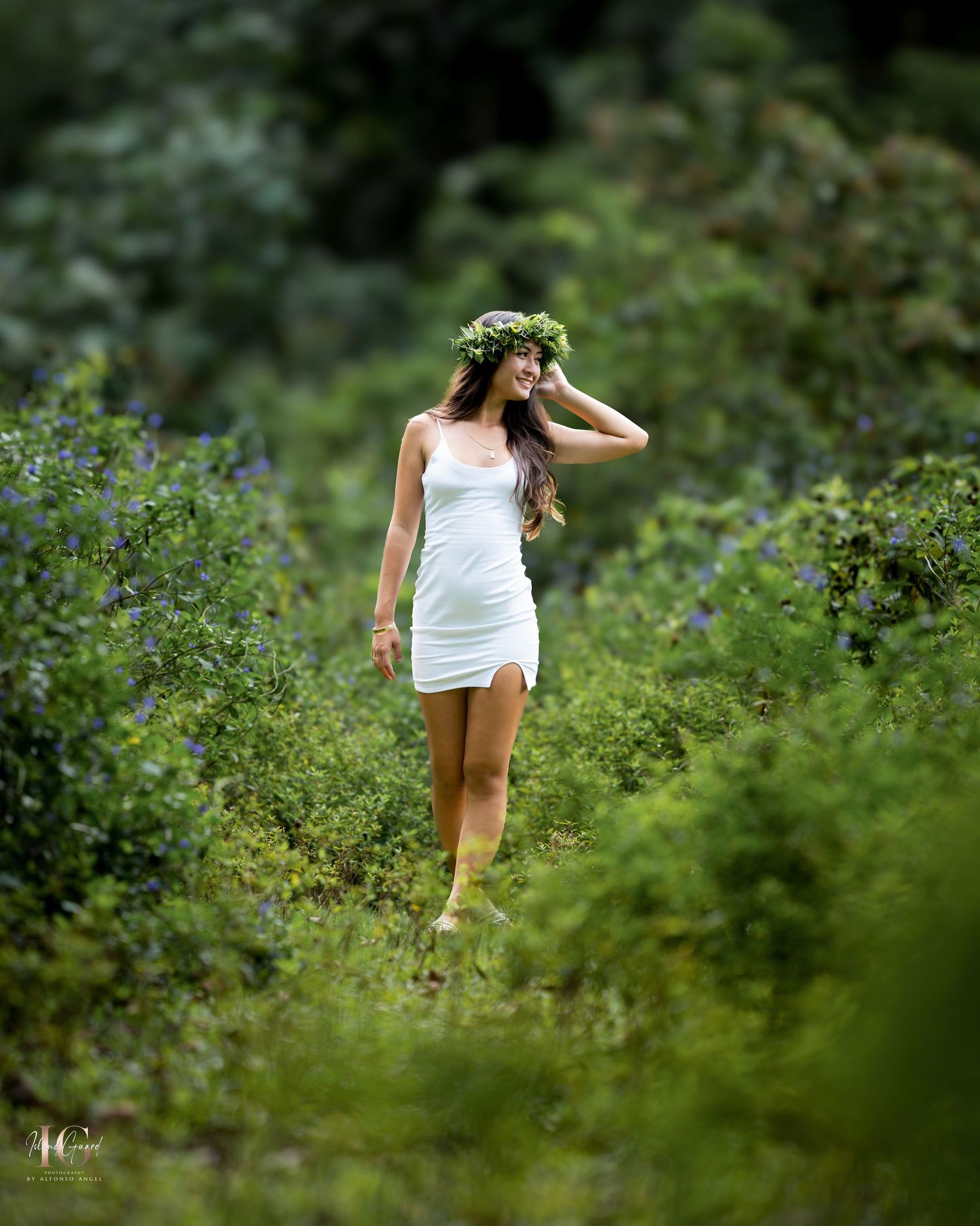 A figure in a white dress walks through lush green foliage in a dreamy outdoor setting.