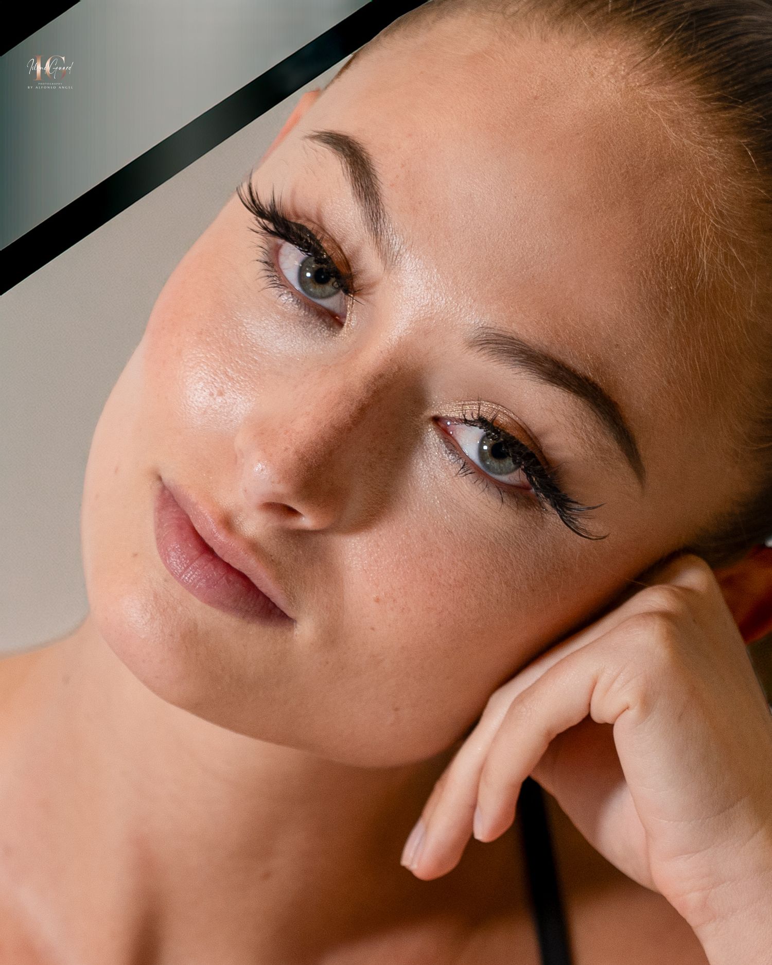 Close up beauty portrait with natural makeup and soft lighting against dark background.