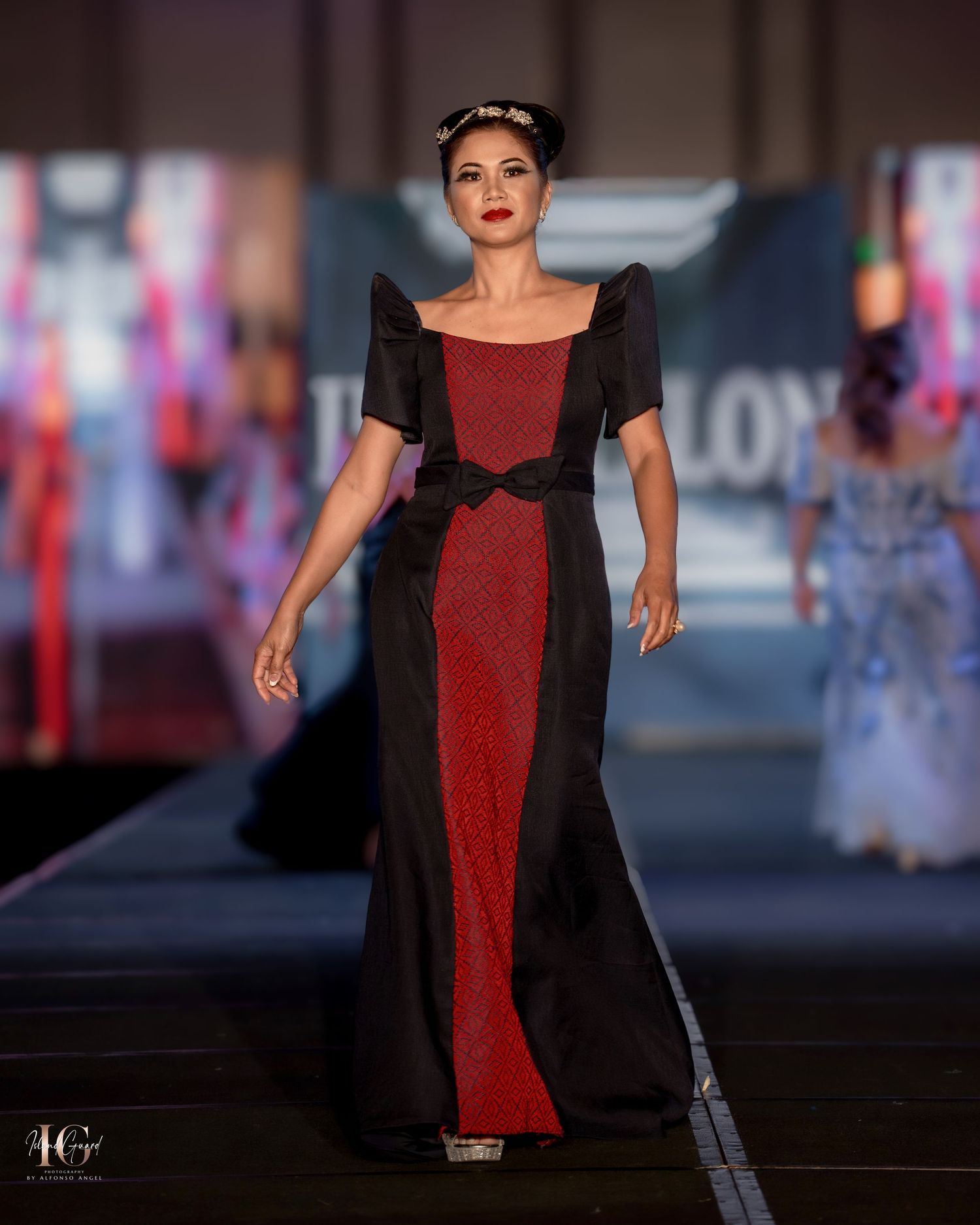 Elegant evening gown featuring red and black color blocking with short sleeves on fashion runway.