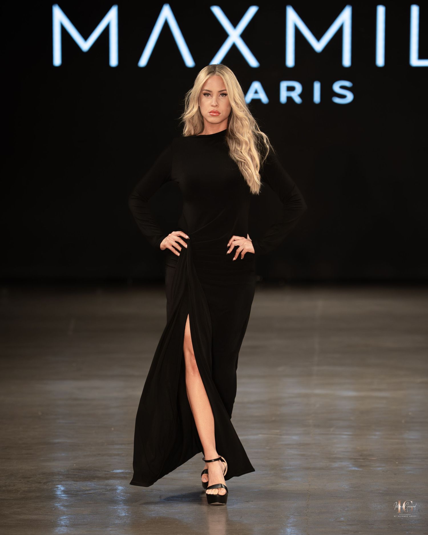 Model walks the runway in a black evening gown with thigh-high slit during Paris Fashion Week.