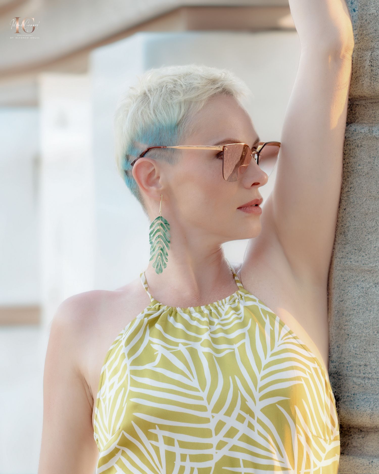 Close-up shot of someone wearing yellow geometric patterned sleeveless top against soft neutral background.