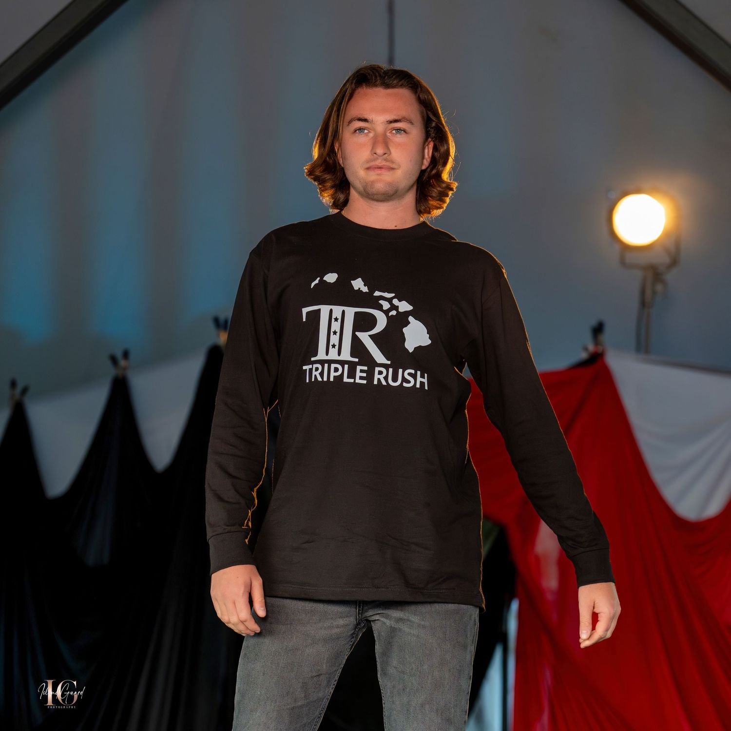 Models wear casual black t-shirts and jeans walking fashion runway.