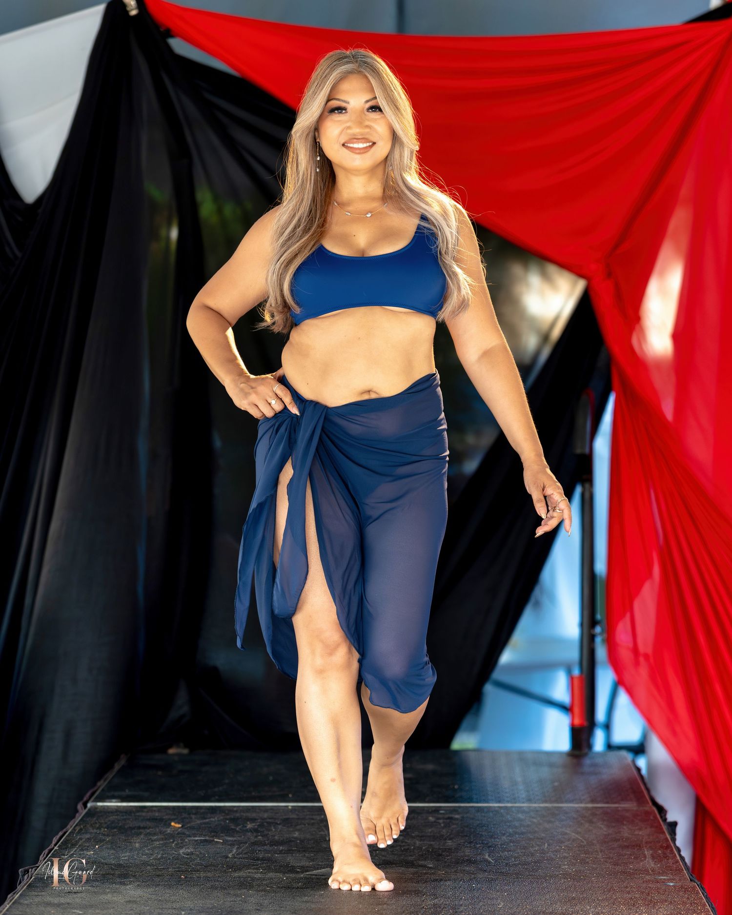 Model showcases navy athletic wear on catwalk with coordinated wrap detail.