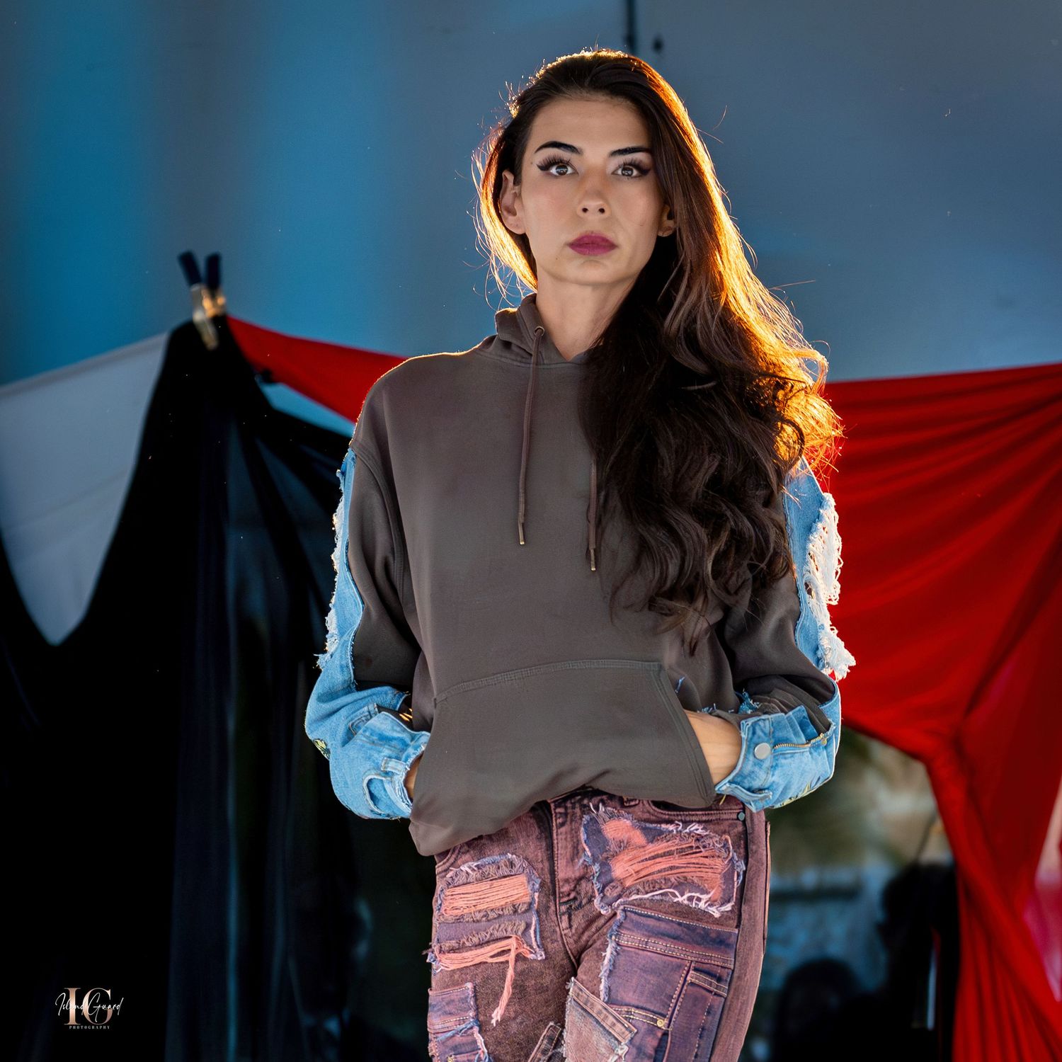 Fashion model showcasing brown turtleneck with pink patterned pants on catwalk.